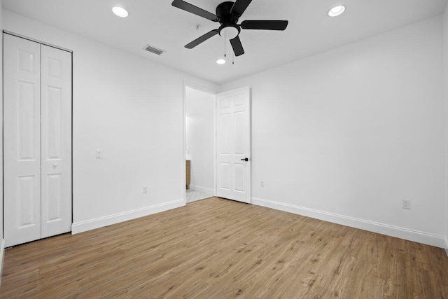 unfurnished bedroom with ceiling fan, a closet, and light wood-type flooring