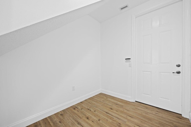 unfurnished room with lofted ceiling and wood-type flooring