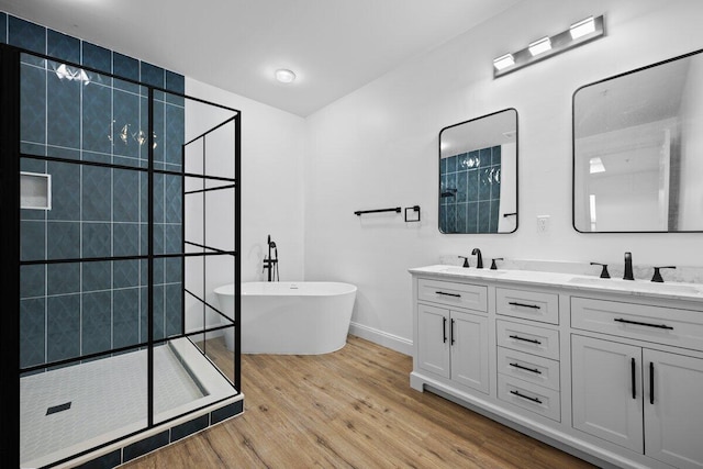 bathroom featuring hardwood / wood-style floors, plus walk in shower, and vanity