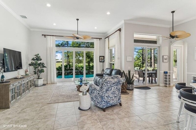 tiled living room with ornamental molding and ceiling fan