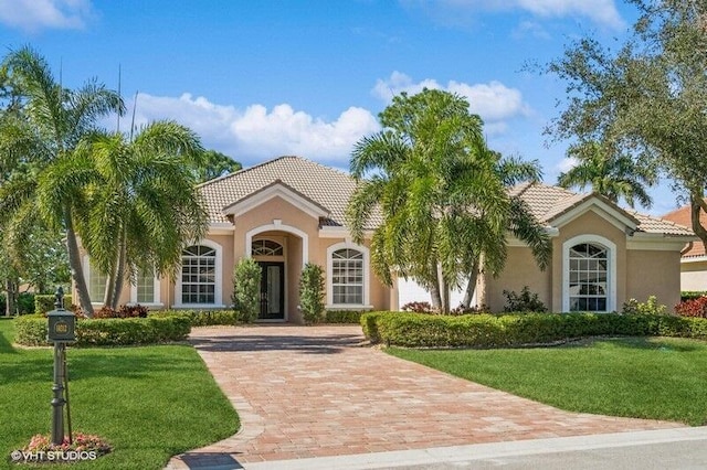 mediterranean / spanish home featuring a front yard