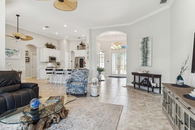 tiled living room featuring ornamental molding, french doors, and ceiling fan