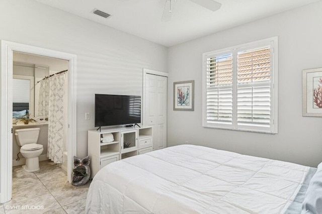 tiled bedroom featuring connected bathroom, a closet, and ceiling fan