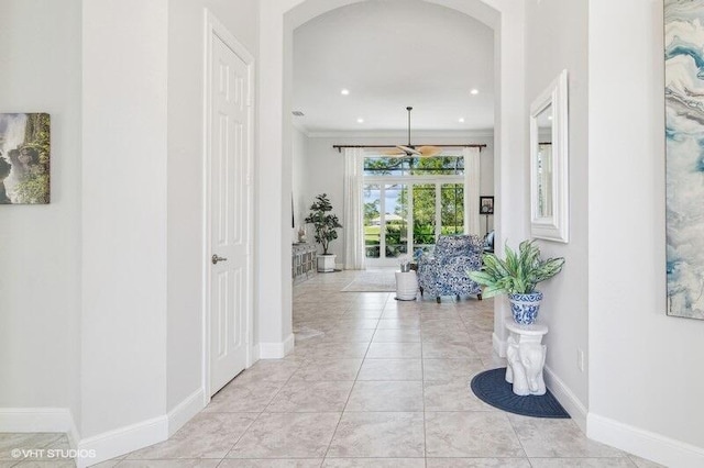 hallway with ornamental molding and light tile patterned floors