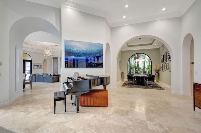 interior space with crown molding, a towering ceiling, and a chandelier