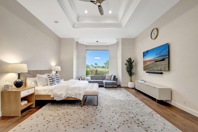 bedroom featuring ornamental molding, hardwood / wood-style floors, and a tray ceiling