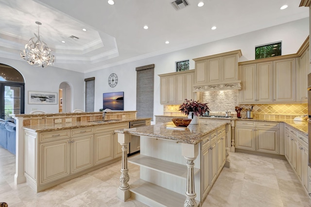 kitchen featuring a kitchen island, pendant lighting, dishwasher, sink, and light stone countertops