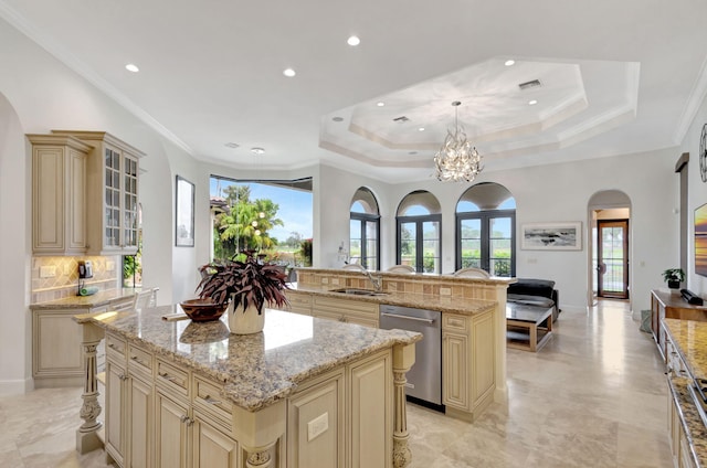 kitchen with pendant lighting, sink, a center island, stainless steel dishwasher, and cream cabinets