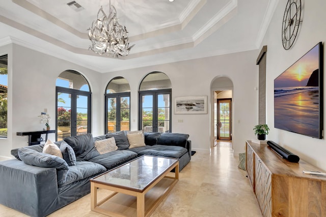 living room with french doors, ornamental molding, and a raised ceiling