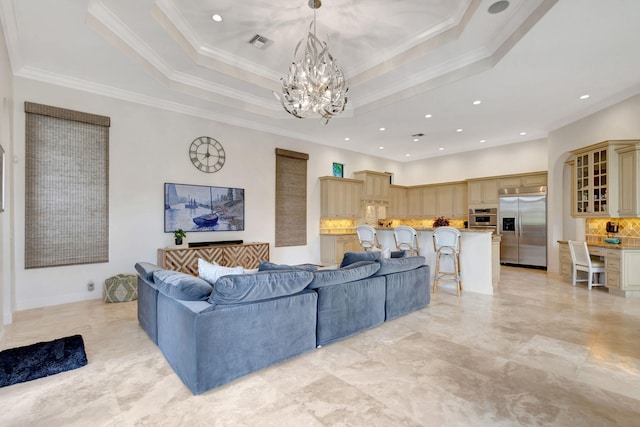 living room featuring crown molding, a chandelier, and a tray ceiling