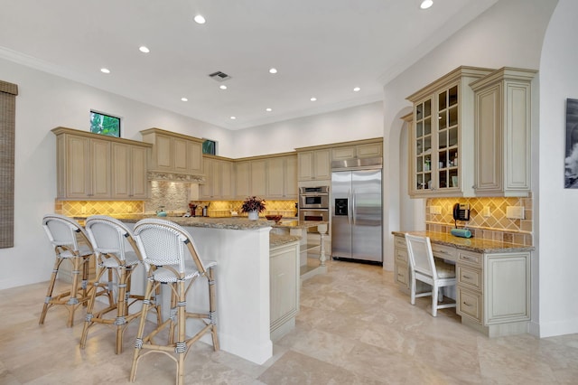 kitchen with a center island, appliances with stainless steel finishes, light stone countertops, and a breakfast bar area