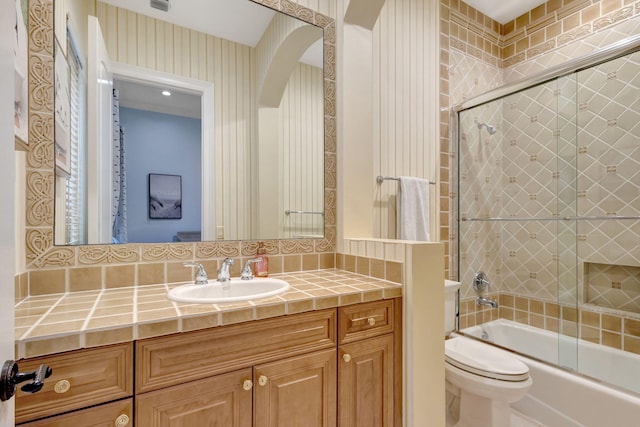 full bathroom with vanity, shower / bath combination with glass door, and toilet