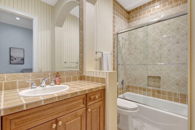 full bathroom featuring vanity, toilet, and combined bath / shower with glass door