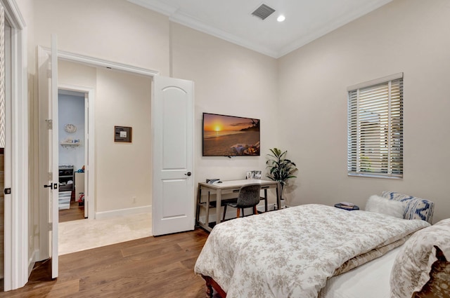 bedroom featuring ornamental molding and hardwood / wood-style floors