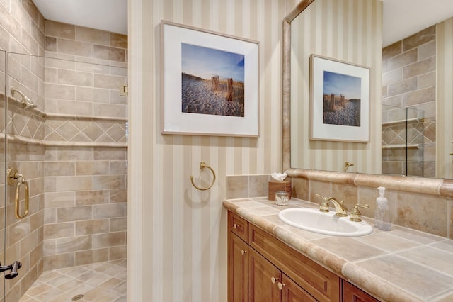 bathroom with vanity and a tile shower