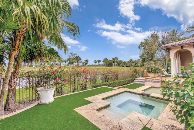 view of pool featuring an in ground hot tub and a lawn