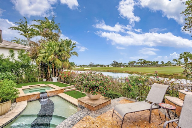 view of patio featuring a water view and an in ground hot tub