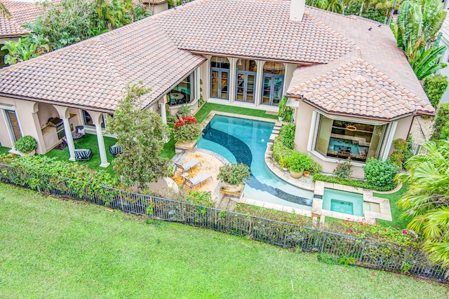 view of swimming pool with a lawn and an in ground hot tub