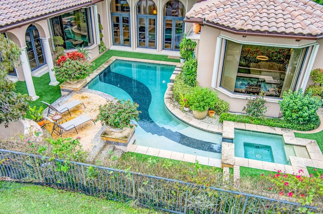 view of swimming pool with an in ground hot tub