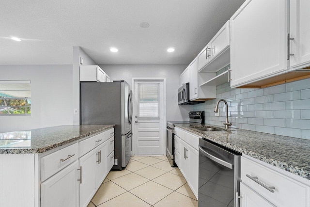 kitchen with sink, stainless steel appliances, white cabinets, and light stone countertops