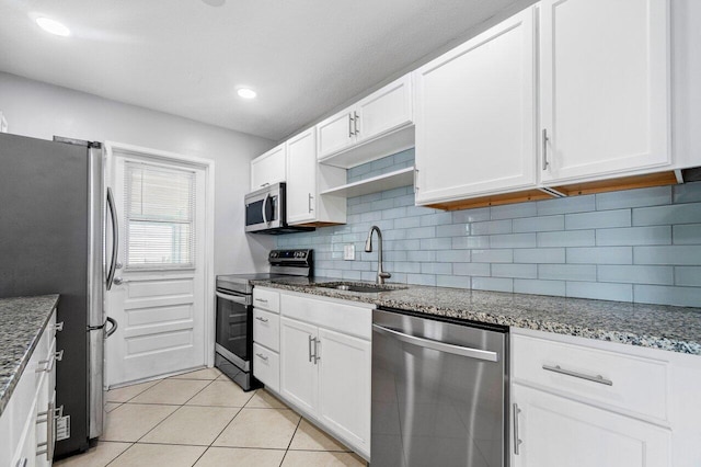 kitchen featuring white cabinetry, appliances with stainless steel finishes, sink, and light tile patterned flooring