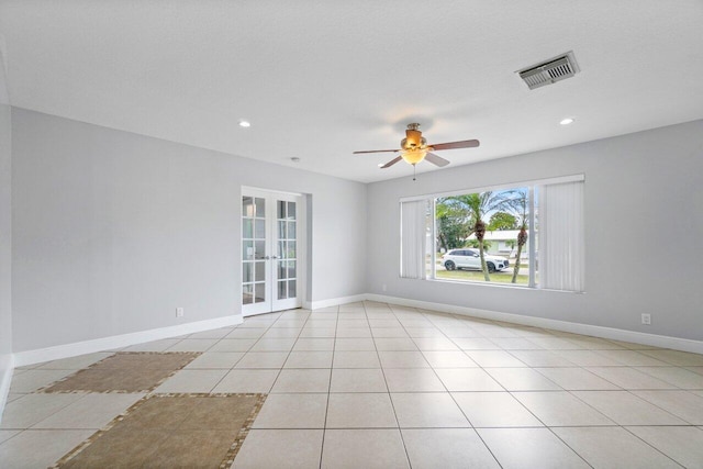 spare room with a textured ceiling, french doors, ceiling fan, and light tile patterned flooring