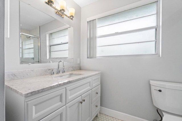 bathroom with a shower with door, vanity, plenty of natural light, and toilet