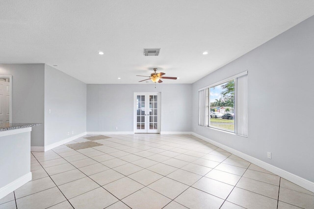 spare room featuring french doors, ceiling fan, and light tile patterned flooring