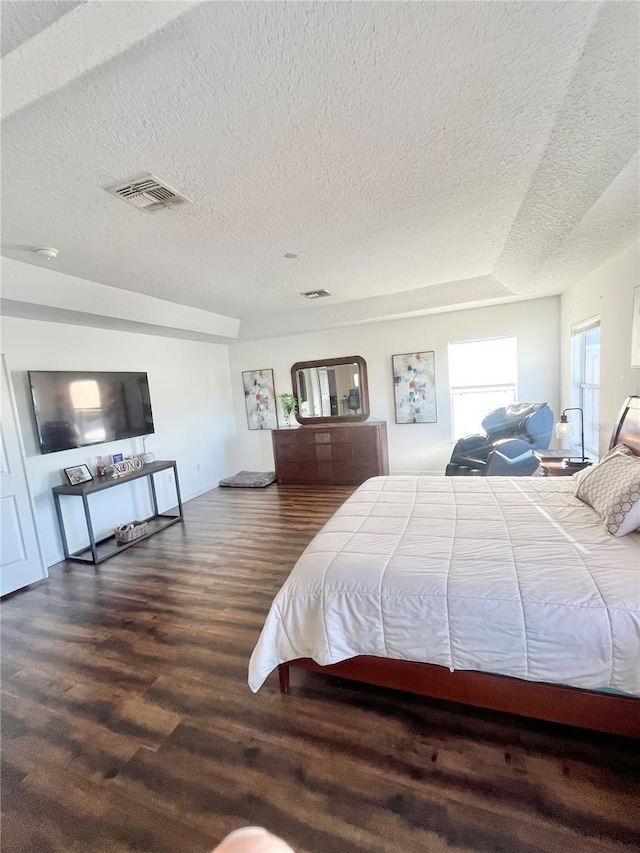 bedroom with dark wood-type flooring and a textured ceiling