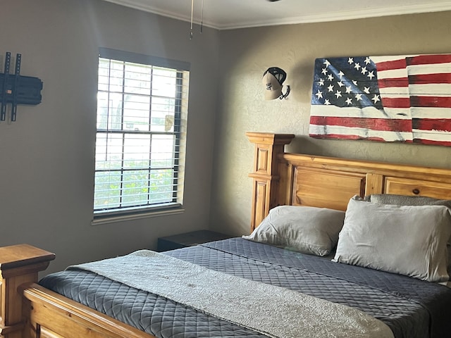 bedroom featuring crown molding and a textured wall