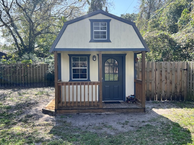 view of outdoor structure featuring fence and an outbuilding