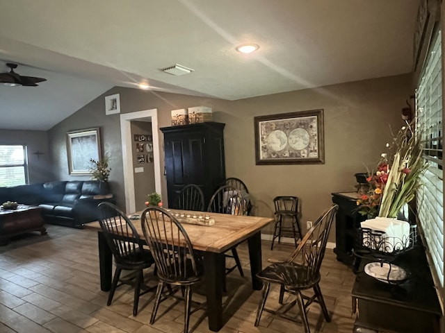 dining room with vaulted ceiling, light wood finished floors, and a ceiling fan