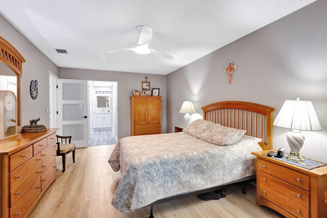 bedroom with ceiling fan, light hardwood / wood-style flooring, and ensuite bath