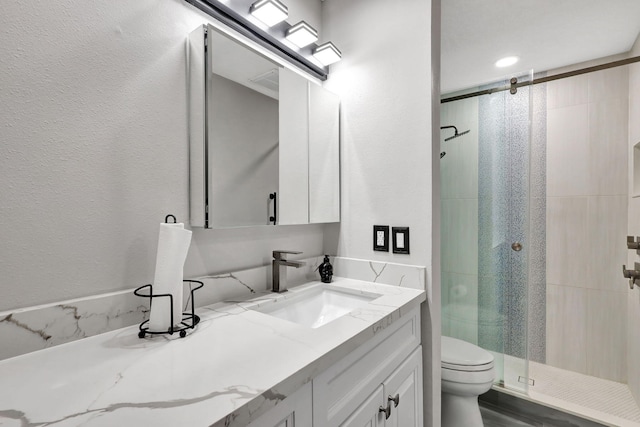 bathroom featuring toilet, an enclosed shower, and vanity