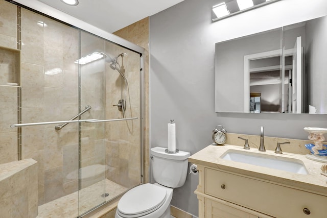 bathroom featuring toilet, walk in shower, and vanity