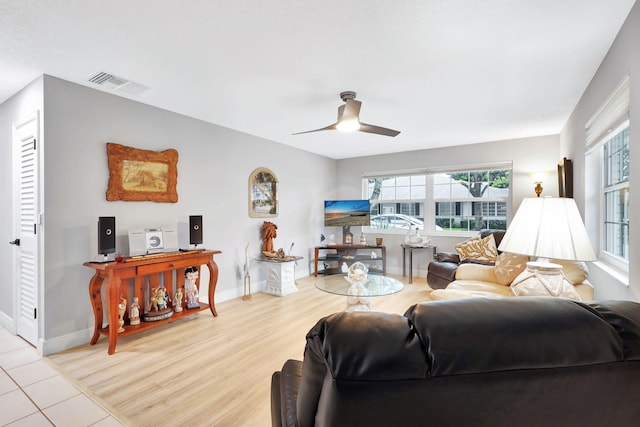 tiled living room with ceiling fan