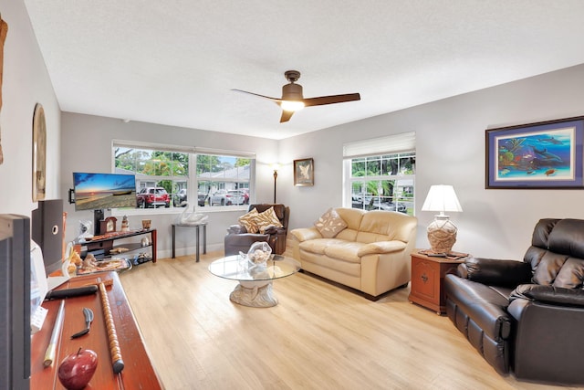 living room with light wood-type flooring, ceiling fan, and a healthy amount of sunlight