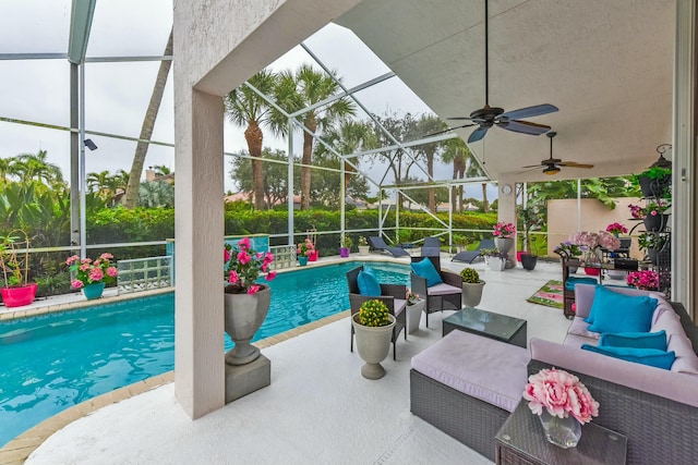 view of swimming pool featuring ceiling fan, an outdoor living space, a lanai, and a patio