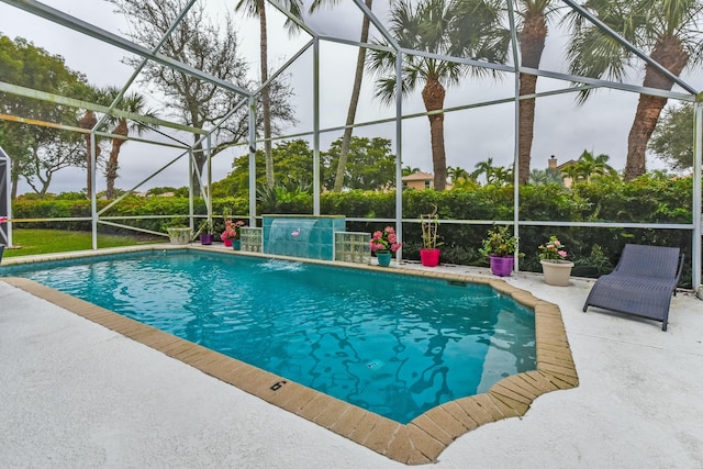 view of swimming pool featuring pool water feature, a patio, and glass enclosure