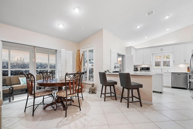 tiled dining area with lofted ceiling