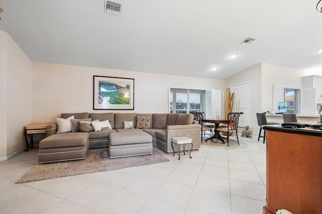 tiled living room featuring vaulted ceiling