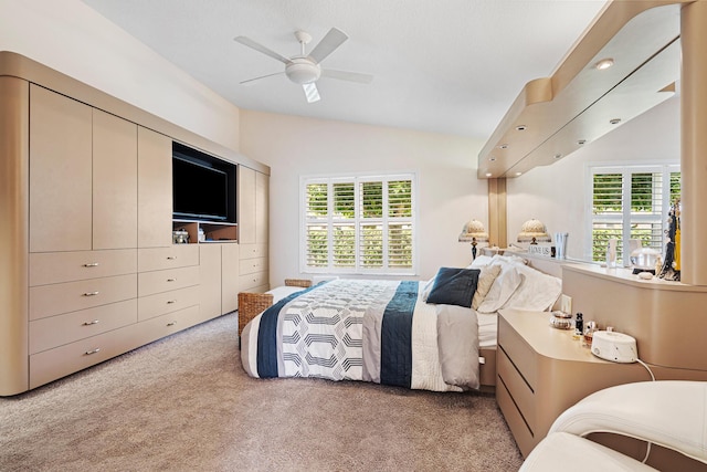 bedroom featuring ceiling fan, light colored carpet, vaulted ceiling, and multiple windows