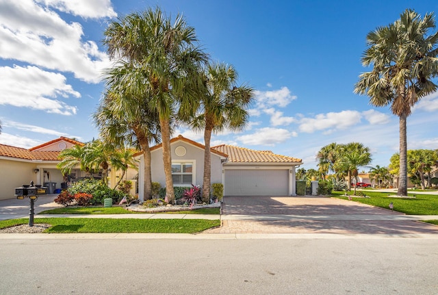 mediterranean / spanish home featuring a front yard and a garage