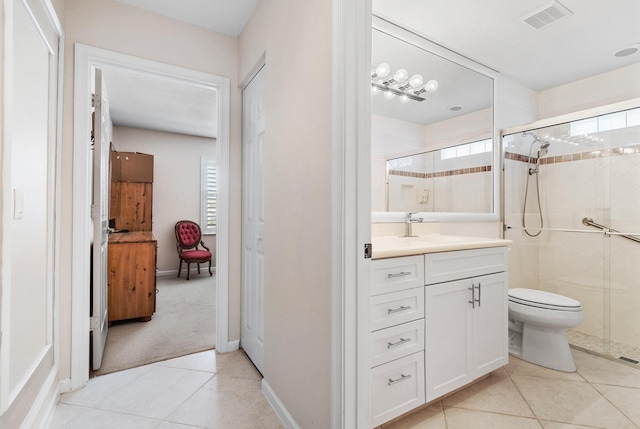 bathroom featuring walk in shower, vanity, tile patterned floors, and toilet