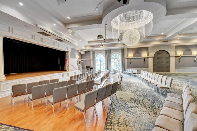 home theater room with hardwood / wood-style flooring and a raised ceiling