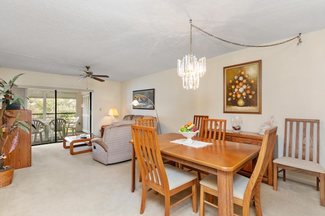 dining room featuring ceiling fan, a textured ceiling, and light carpet