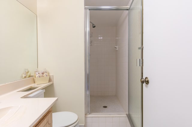 bathroom featuring vanity, toilet, tile patterned floors, and a shower with door