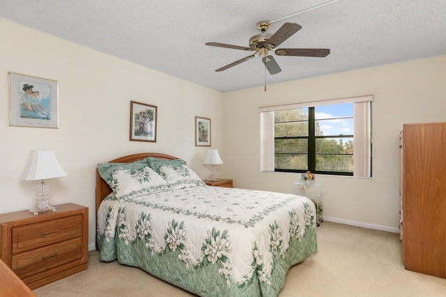 carpeted bedroom with ceiling fan and a textured ceiling