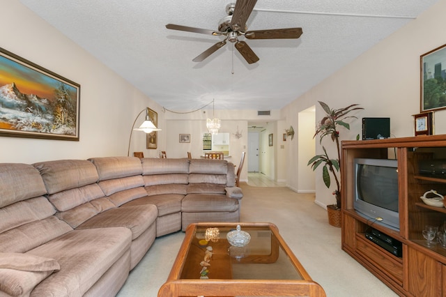 carpeted living room featuring ceiling fan and a textured ceiling