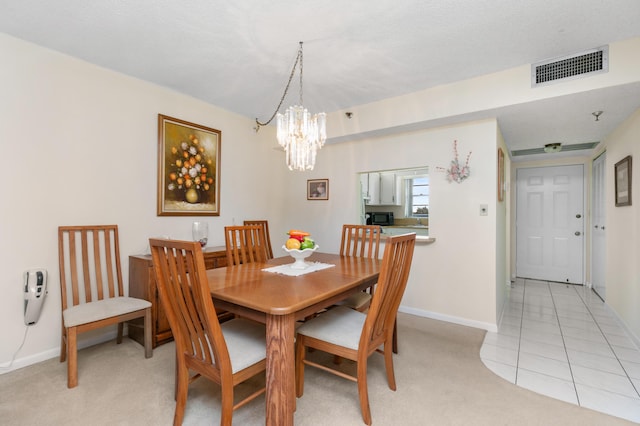 carpeted dining area with a textured ceiling and a chandelier